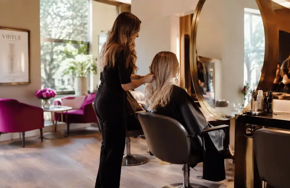 Hairstylist styling a client's hair in a modern salon